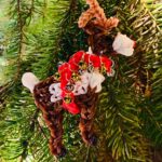 Handmade Rudolph the Red-Nosed Reindeer Christmas ornament made from rubber bands with a red rhinestone nose and jingle bells.