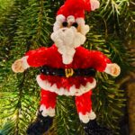 Jolly handmade Santa Claus Christmas ornament made from red and white rubber bands with sparkling rhinestone eyes.