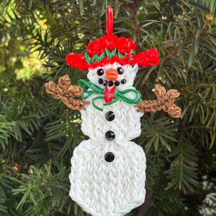 Tundra the Snowlady Christmas ornament with a red hat and rhinestone features, made from white and black rubber bands.